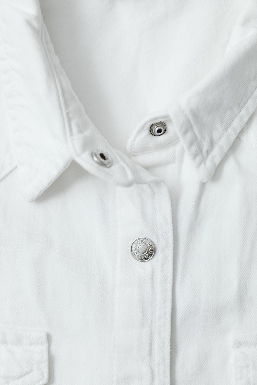 close up photo of a white shirt with silver buttons