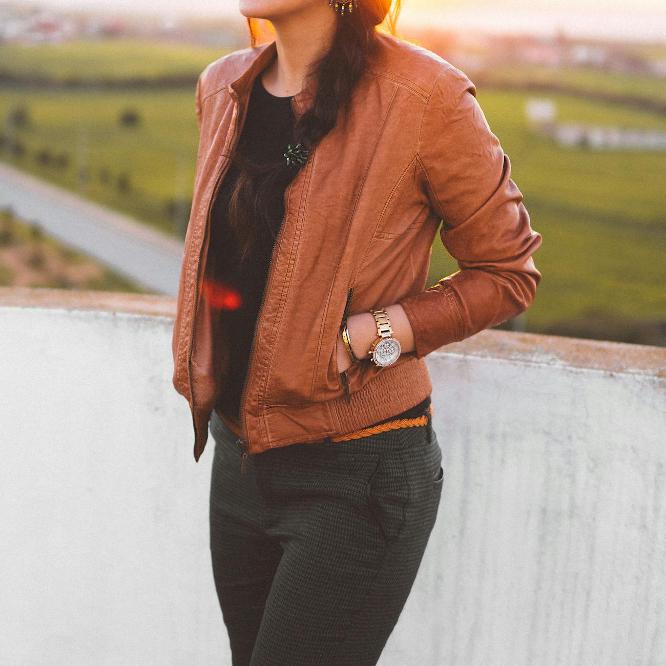 woman wearing brown leather jacket and black pants